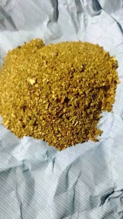 Pile of raw alluvial gold dust from Kenya on a white cloth before assay